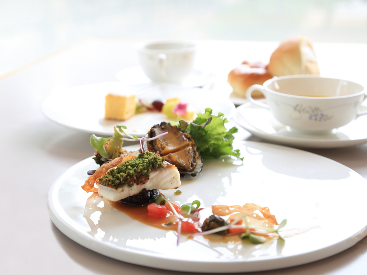 白い皿をキャンバスに見立てた美しい盛り付けの料理が揃います